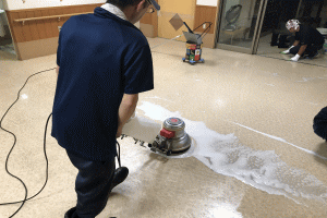 回転式床掃除機で掃除する作業員の画像